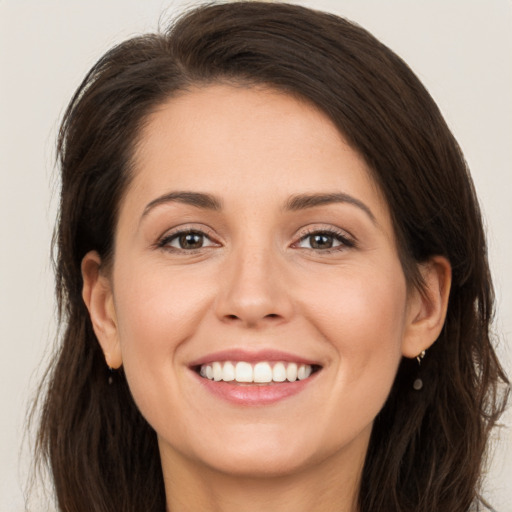 Joyful white young-adult female with long  brown hair and brown eyes