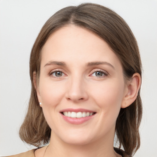 Joyful white young-adult female with long  brown hair and grey eyes