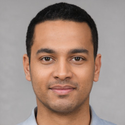 Joyful latino young-adult male with short  black hair and brown eyes