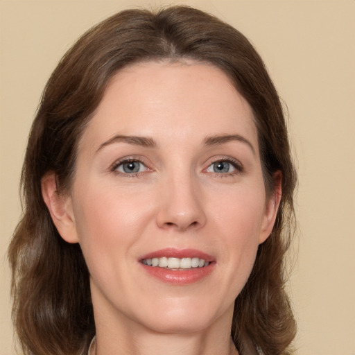 Joyful white adult female with long  brown hair and grey eyes