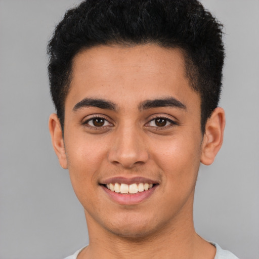 Joyful latino young-adult male with short  brown hair and brown eyes