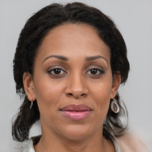 Joyful black adult female with medium  brown hair and brown eyes
