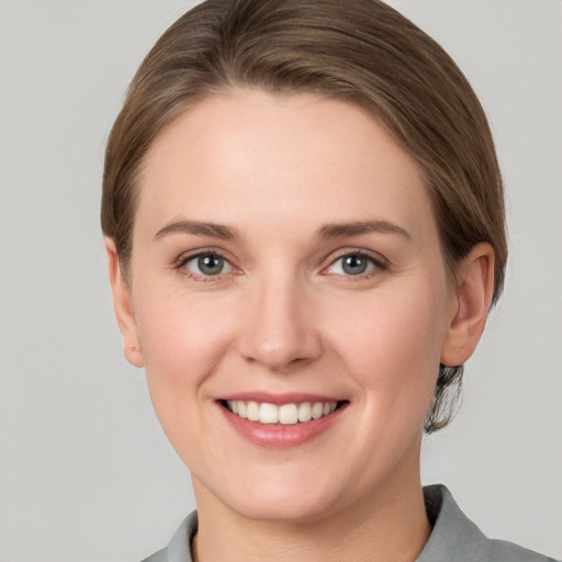 Joyful white young-adult female with short  brown hair and grey eyes