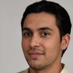 Joyful white young-adult male with short  black hair and brown eyes