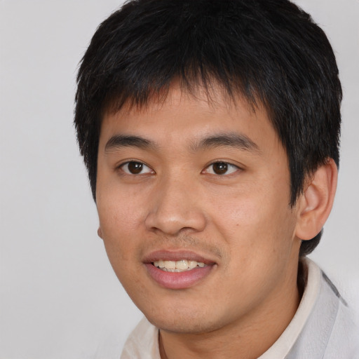 Joyful asian young-adult male with short  brown hair and brown eyes