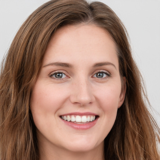 Joyful white young-adult female with long  brown hair and green eyes