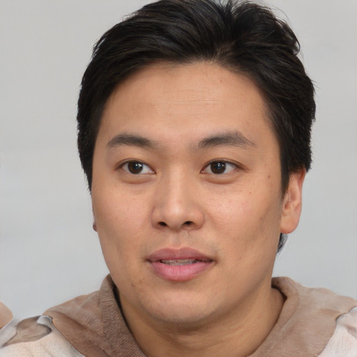 Joyful asian young-adult male with short  brown hair and brown eyes