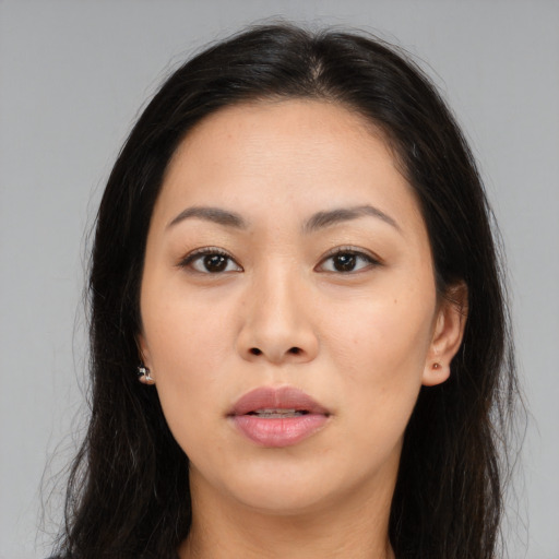 Joyful asian young-adult female with long  brown hair and brown eyes