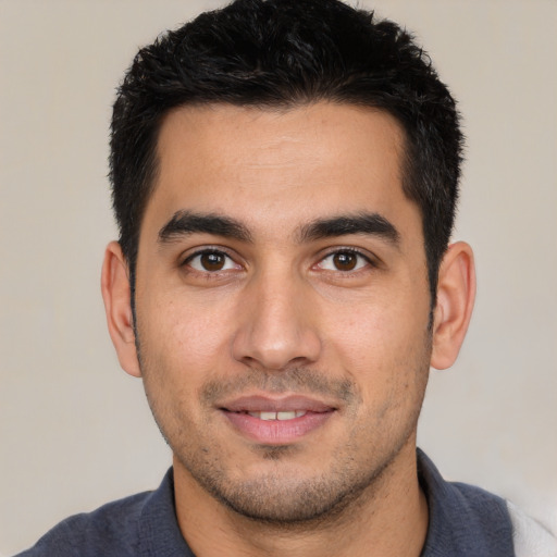 Joyful white young-adult male with short  black hair and brown eyes