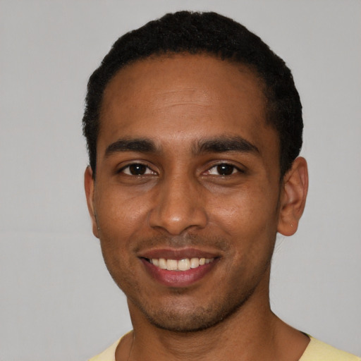 Joyful black young-adult male with short  black hair and brown eyes