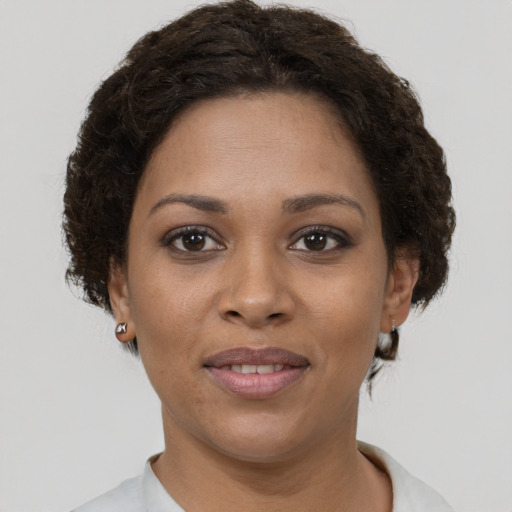 Joyful black young-adult female with short  brown hair and brown eyes