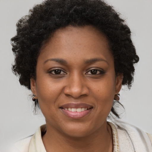 Joyful black young-adult female with short  brown hair and brown eyes