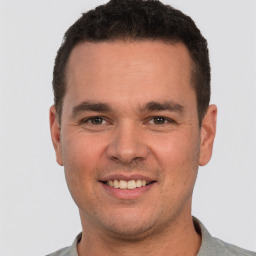 Joyful white young-adult male with short  brown hair and brown eyes