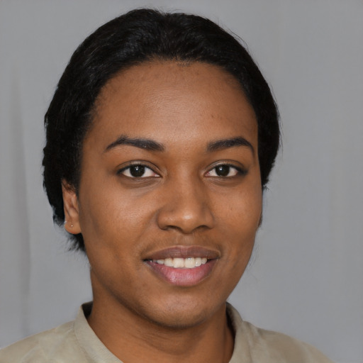 Joyful black young-adult female with short  black hair and brown eyes