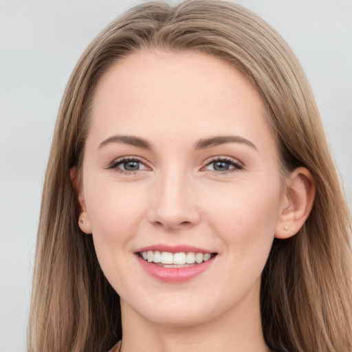 Joyful white young-adult female with long  brown hair and grey eyes