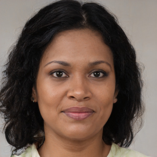 Joyful black young-adult female with medium  brown hair and brown eyes