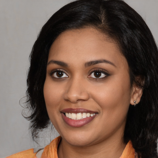 Joyful latino young-adult female with medium  black hair and brown eyes
