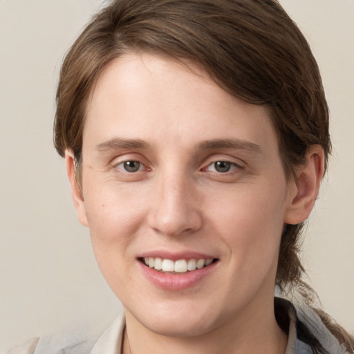 Joyful white young-adult female with medium  brown hair and grey eyes