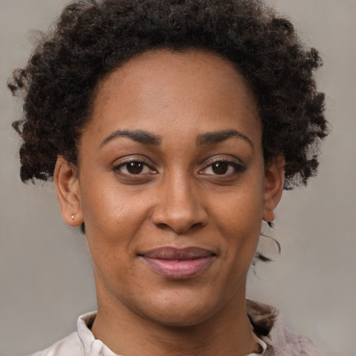 Joyful black adult female with short  brown hair and brown eyes