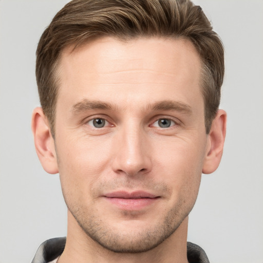 Joyful white young-adult male with short  brown hair and grey eyes