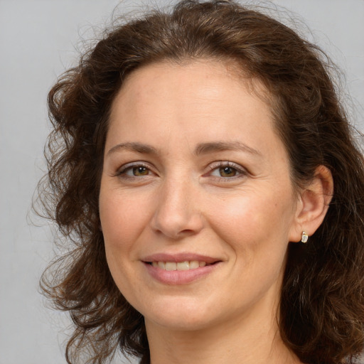 Joyful white adult female with long  brown hair and brown eyes