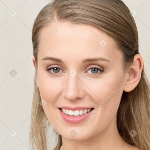 Joyful white young-adult female with long  brown hair and blue eyes