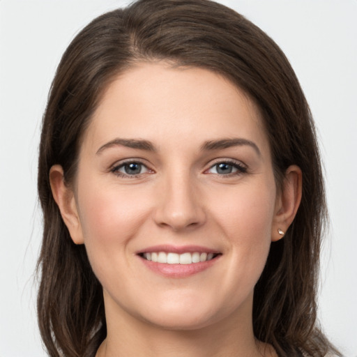 Joyful white young-adult female with long  brown hair and grey eyes