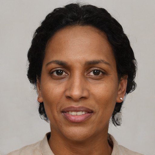 Joyful black adult female with short  black hair and brown eyes