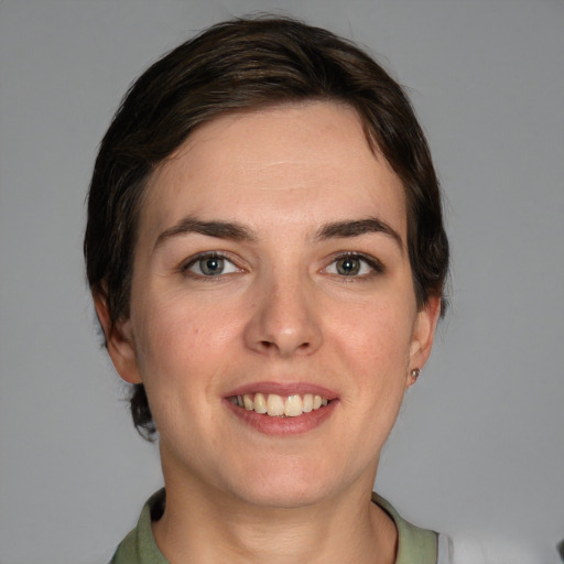 Joyful white young-adult female with short  brown hair and grey eyes