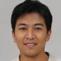 Joyful asian young-adult male with short  black hair and brown eyes