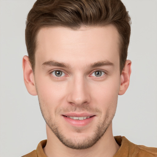 Joyful white young-adult male with short  brown hair and grey eyes