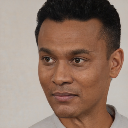 Joyful black young-adult male with short  black hair and brown eyes
