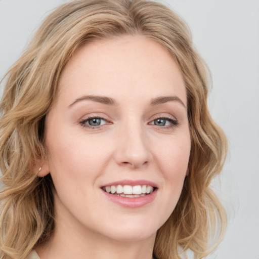 Joyful white young-adult female with long  brown hair and blue eyes