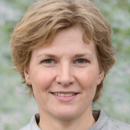 Joyful white adult female with medium  brown hair and grey eyes