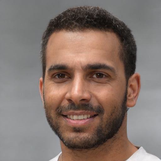 Joyful white young-adult male with short  black hair and brown eyes