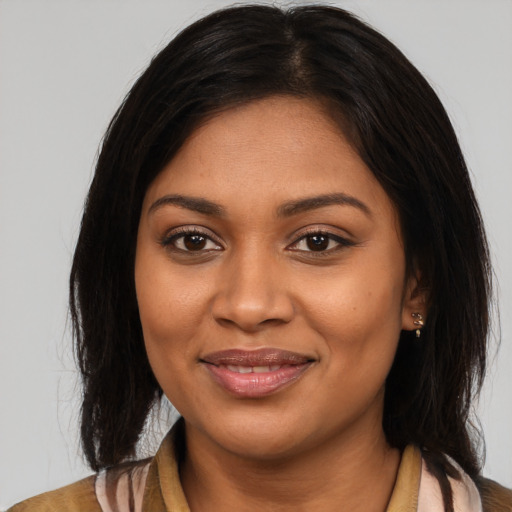Joyful black young-adult female with long  brown hair and brown eyes