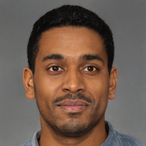 Joyful latino young-adult male with short  brown hair and brown eyes