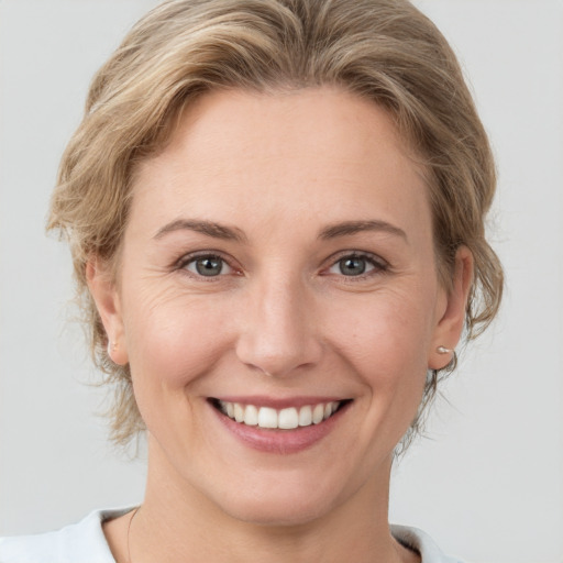 Joyful white young-adult female with short  brown hair and grey eyes