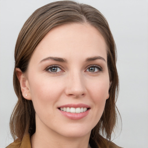 Joyful white young-adult female with long  brown hair and grey eyes