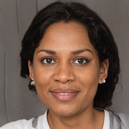Joyful black adult female with medium  black hair and brown eyes