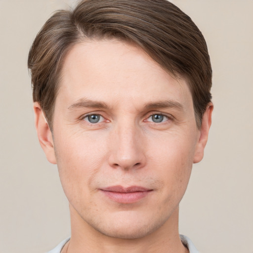 Joyful white young-adult male with short  brown hair and grey eyes