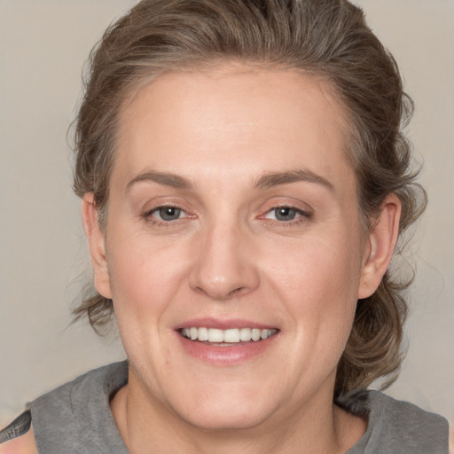 Joyful white adult female with medium  brown hair and grey eyes