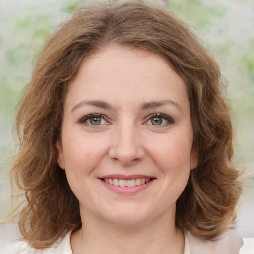 Joyful white young-adult female with medium  brown hair and green eyes