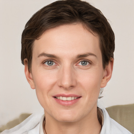 Joyful white young-adult female with short  brown hair and grey eyes