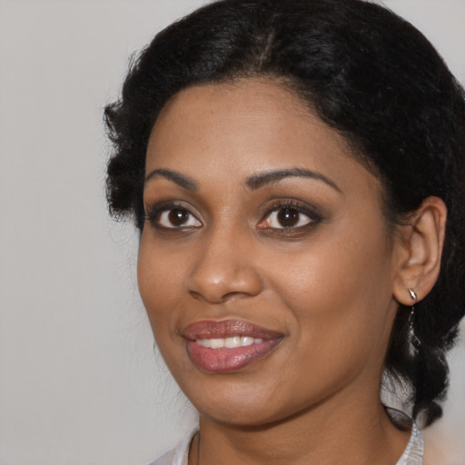 Joyful black young-adult female with medium  black hair and brown eyes