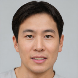 Joyful asian young-adult male with short  brown hair and brown eyes