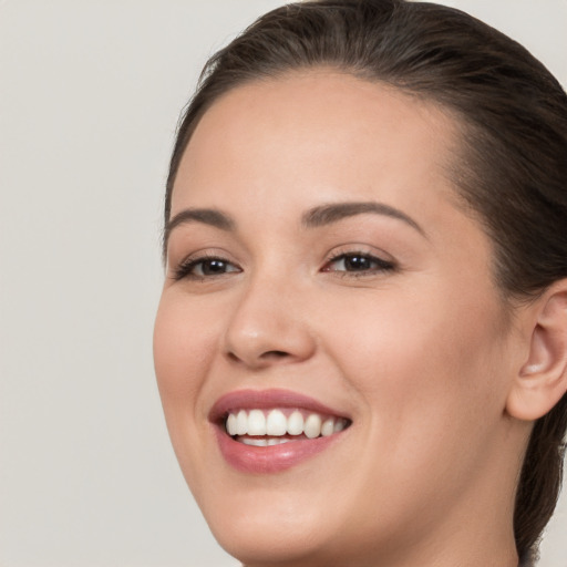 Joyful white young-adult female with long  brown hair and brown eyes