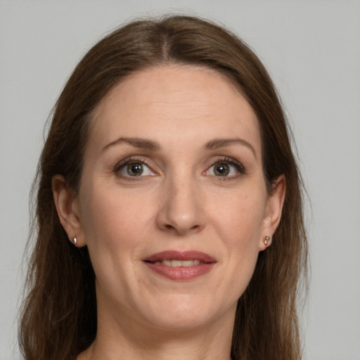 Joyful white adult female with long  brown hair and grey eyes