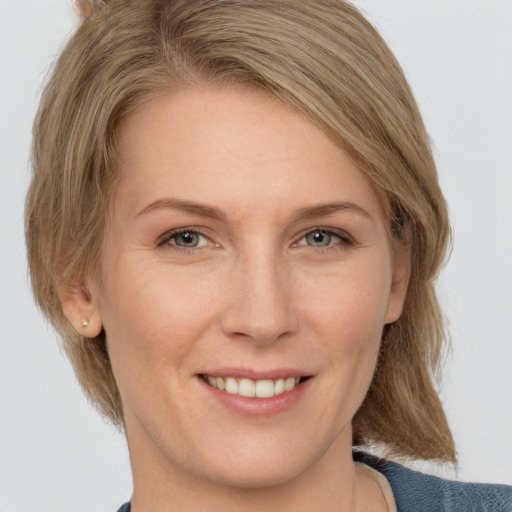 Joyful white adult female with medium  brown hair and brown eyes