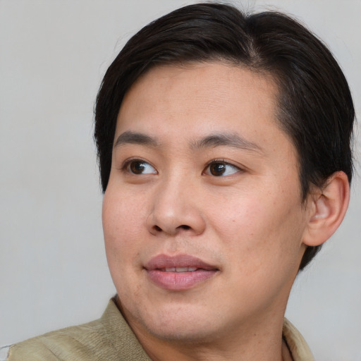 Joyful asian young-adult male with short  brown hair and brown eyes